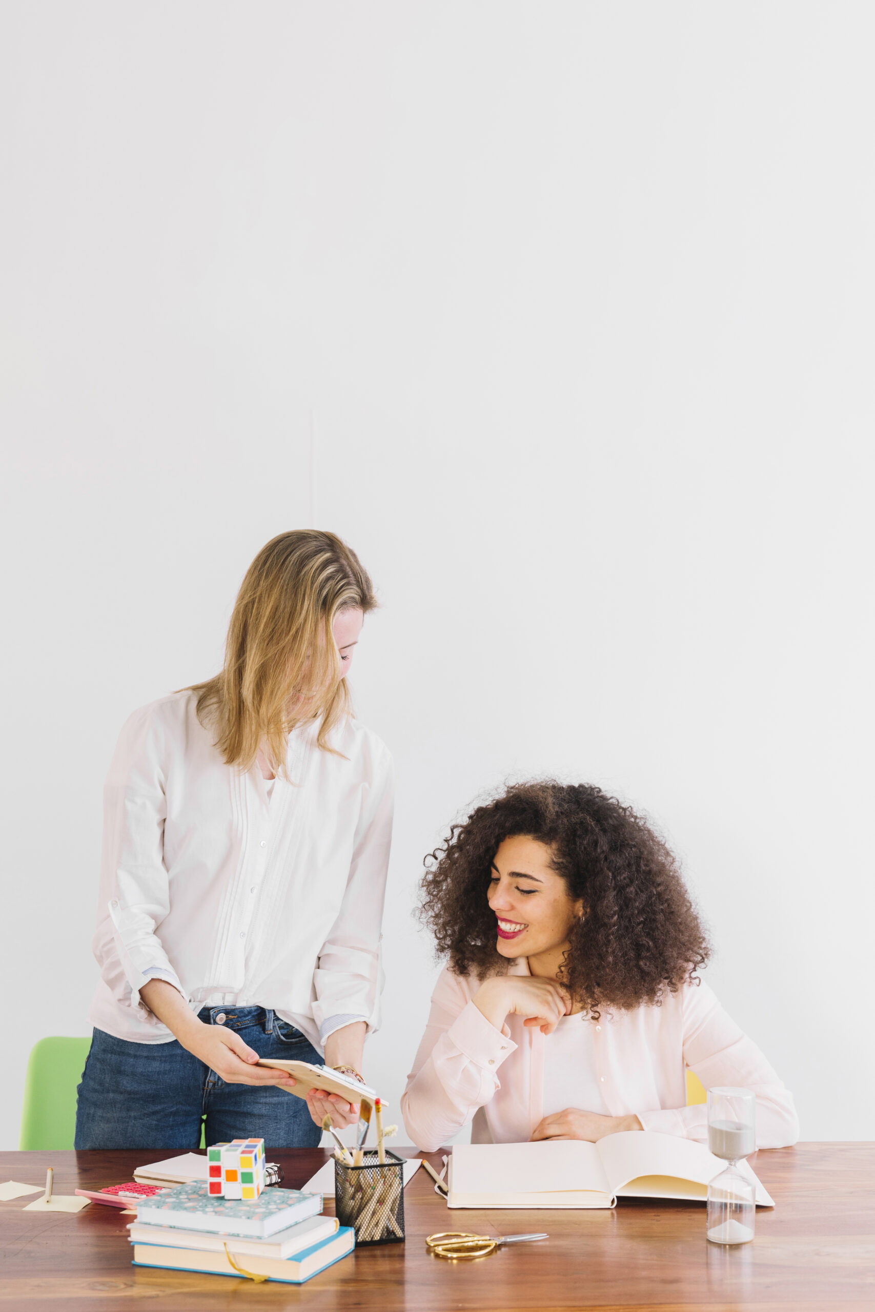 cheerful-women-studying-together-table